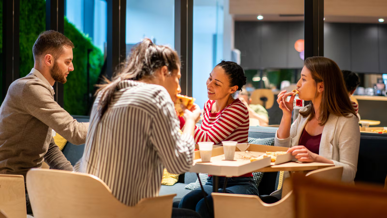 Employees gather around an office snack area, symbolizing how free food remains an important part of media agency culture despite upcoming tax changes.